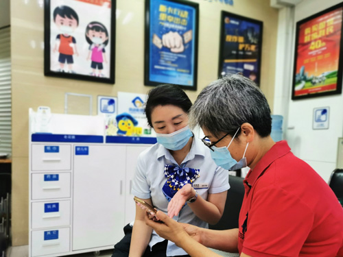 建行成都第六支行，大堂經(jīng)理為客戶介紹手機(jī)銀行“大字”模式